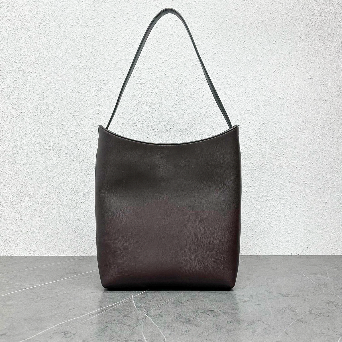 Arc Shoulder Bag in Dark Brown, front view with curved opening and single strap
