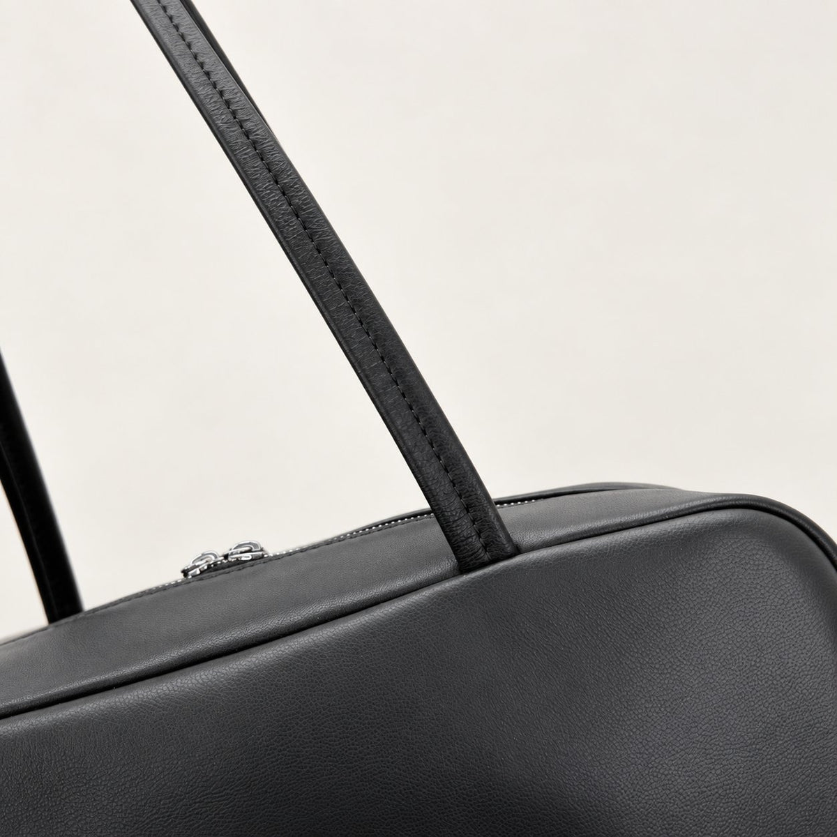 Nina Mini Bowling Bag in Black, handle attachment and leather detail